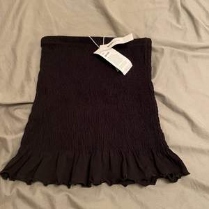 Svart kjol från ginatrickot med en detalj på slutet🖤 stl M