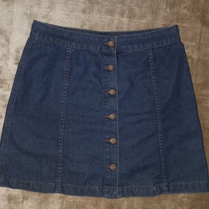 Jeanskjol från new Yorker storlek Large - Söt vardaglig A-linje Jeanskjol med knappar fram från new Yorker storlek Large. Ganska tjockt jeanstyg, ej strech material. Går in snyggt i midjan. Köparen står för frakten. 