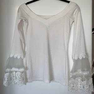 Off-shoulder topp i vitt - Gullig vit off-shoulder topp med vackra detaljer vid ärmslut. 