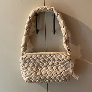Beige axelväska  - Beige axelväska från Gina Tricot. Aldrig använd med prislappen kvar. Säljer för att den inte kommer till användning. Originalpris: 399kr. Kan mötas upp i Stockholm eller posta. Frakt 66kr spårbart 🖤