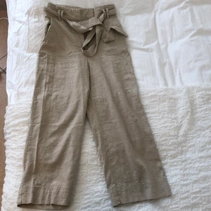 H&M byxor storlek 38 - Beiga hödmidjade byxor med skärp och lite kortare ben i linneblandning från H&M! Använda 2 gånger 🤍 