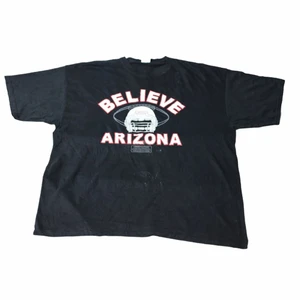 Believe Arizona - Vintage T-shirt - En svart oversized t-shirt som består av ett vitt print. Den är från en amerikansk high school och deras fotbollslag. Det är ett detaljerat print som har stor potential för att skapa en sjukt Nice outfit! 