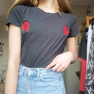 Svart T-shirt med rosor från Bikbok - Säljer denna svarta T-shirten från Bikbok med röda rosor på framsidan, storlek XS❤️