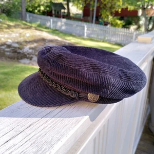 Trendig keps  - Svart keps med platt kulle (Fiddler Cap), köpt på Beyond Retro för 350kr. Välgjord. Har inte kommit till användning. Storlek S. Frakt tillkommer.