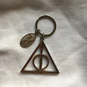 Harry Potter nyckelring - Nyckelring med deathly hallows från Harry Potter. Äkta merch köpt på Wizarding World i Florida. Berlocken är ca 4cm. Som ny.