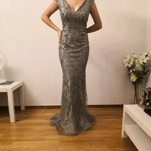 En fin lång klänning i grått och beige med mycket fina detaljer.  - Klänningen är i storlek 38 och användes endast en gång i en klänning i somras då den köptes. 