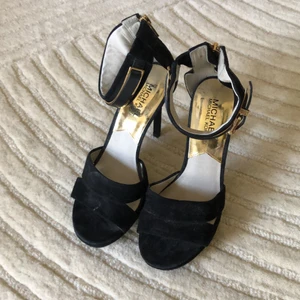 Grymma skor Michael Kors - Superfina svarta mockasjor från Michael Kors, klacken är 11 cm hög. Lätta att ta av o på med dragkedja baktill. Inga skador då jag vart väldigt rädd om dem