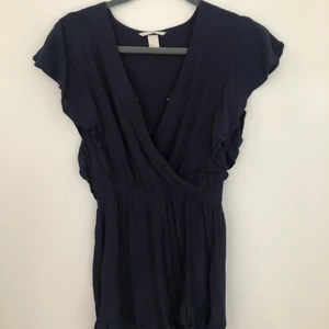 Mörkblå jumpsuit från HM - Somrig mörkblå kort jumpsuit i storlek 34 men passar också storlek 36💙 den går att knäppa där fram så man kan bestämma hur urringad man vill att den ska vara. 50kr +frakt