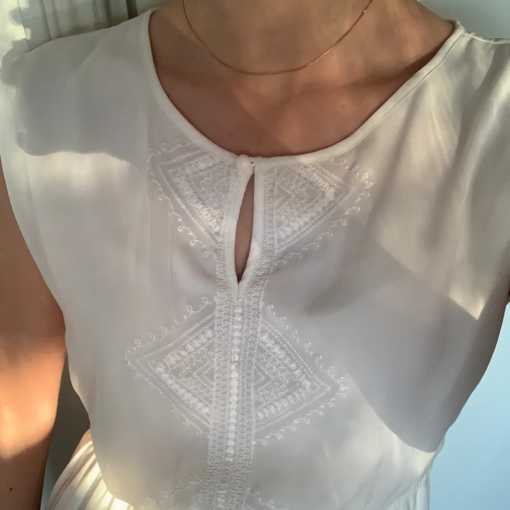 Vit klänning från VILA med vita broderade detaljer. Sparsamt använd, mycket fint skick 🤍 Storlek S Kolla gärna in mina andra annonser!. Klänningar.