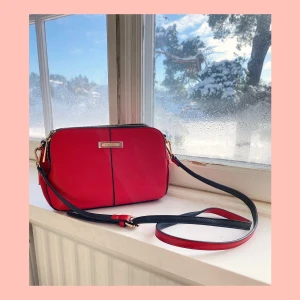 Red Hand Bag w Adjustable Shoulder Strap  - Structured, keeps it’s shape nicely. 3 pockets, each with inside pockets. Shoulder strap is adjustable and removable. Fun fact: middle pocket is big enough to fit a Game of Thrones book. Near perfect condition. Original price: 349sek. Shipping not inc.