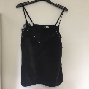 Svart linne  - Svart linne med spets och stenar framtill. Storlek XS men passar S också. 