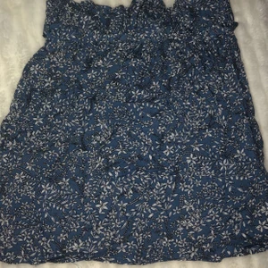 kjol - Blå kjol från shein med blommor och ett ”skärp” i midjan så du kan justera själv hur tajt den ska sitta. Även resår så den sitter skönt. Den är rätt tunn men superskönt material, inte genomskinlig. Aldrig använd 