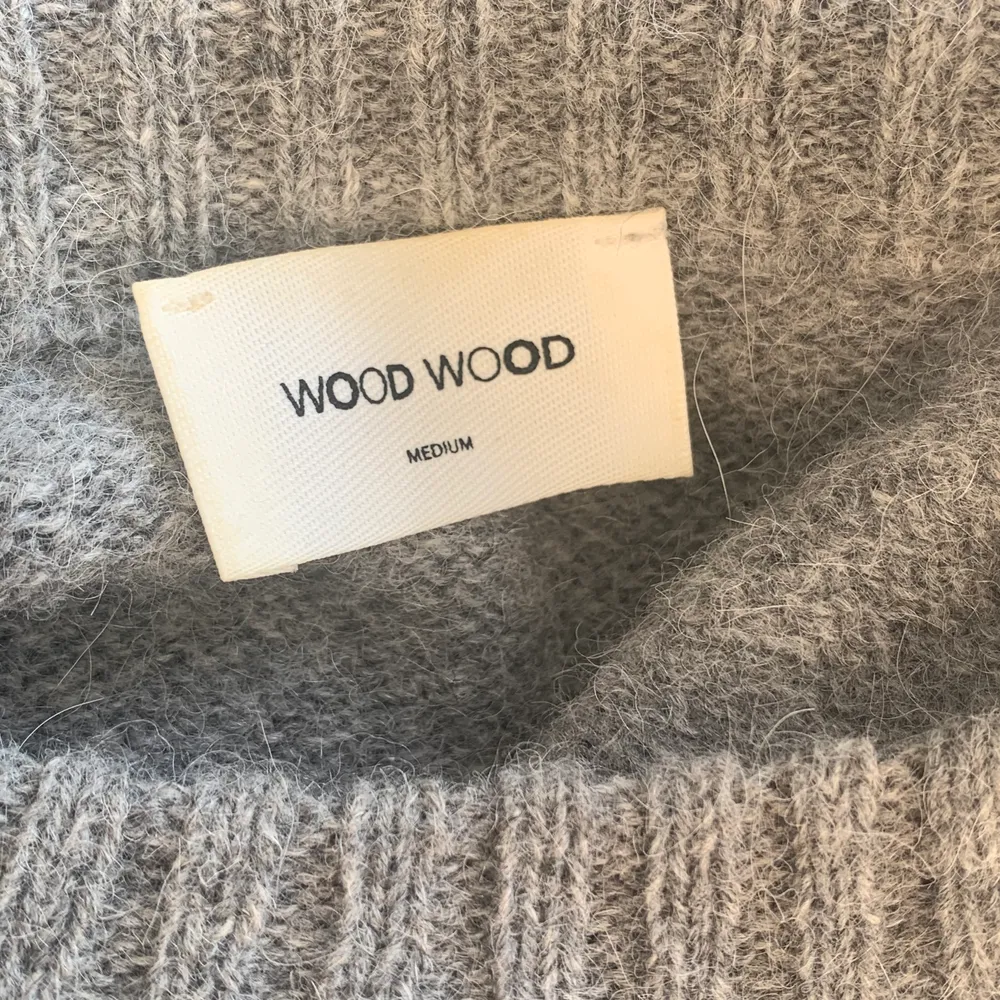 En grå stickad T-shirt från Wood Wood i strl M. 75% ull 15% alpacka. Sparsamt använd! ‼️Budgivning‼️Högsta bud: 400 + frakt ✨✨ köp direkt för 450 + frakt!                Köpt för 1200kr. Stickat.
