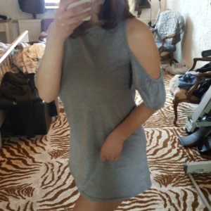 Klänning - En söt grå sommarklänning med volangdetaljer vid ärmarna. Frakt ingår i priset :)