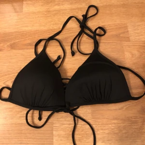 Bikinitopp  - Svart bikinitopp. Snöre i mitten. Storlek 38. Skriv för intresse. Fraktkostnad tillkommer, kan dock mötas i Stockholm :) 