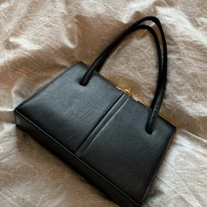 Svart väska med guldiga detaljer - En helt oanvänd väska, säljes för den ej kommer till användning