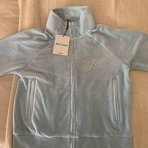 Ljusblå Juicy couture tröja  - En jättefin ljusblå Juicy Couture tröja i storlek S men passar även xs, stenar på både fram och baksida av tröjan. Helt oanvänd och lappen sitter även kvar. Säljer eftersom att den är för liten för mig. Nypris 800kr 🥰 om flera är instresserade buda i kommentarsfältet. 