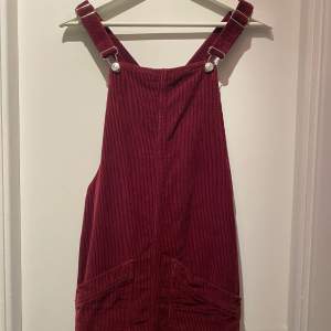 Superfint kort klänning med hängslen och fickor i vinröd manchester. Storlek XS från Topshop. Använd men i väldigt fint skick