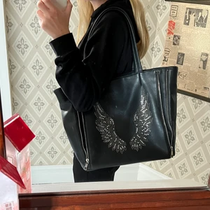 Väska med vingar - Finns det något intresse av att köpa denna fina väska? I mycket bra skick. Den är stor och rymlig med minde fack innuti. Skicka till mig vid intresse eller för fler bilder.