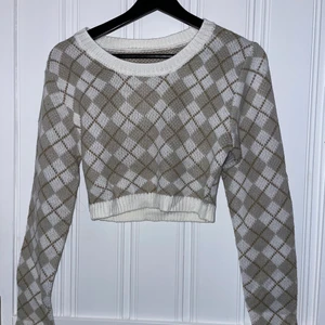 Stickad tröja - Supersöt stickad tröja med rutigt mönster från Shein i väldigt kort modell. Skitsnygg med en tröja under och jeans. Den är i storlek 40 men är mycket liten i storlek så rekommenderar till dig med storlek 34-38 (XS-S) beroende på hur du vill att den ska sitta. Du betalar frakten! Skriv vid frågor eller intresse!💜