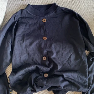 Stickad tröja med knappar - Modellen är lite som en sweatshirt. Knapparna kan man välja att ha bak eller fram. Lappen är bortklippt men skulle säga att det är en s/m.