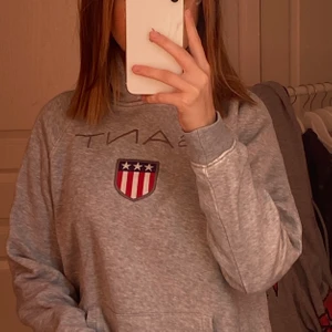 Hoodie från GANT - Grå hoodie från GANT, säljs väldigt billigt då den är väl använd. Köpt från Johnells. Barnstorlek men skulle säga att den passar en XS. Jag är 160 lång och den sitter perfekt i armar och längd.