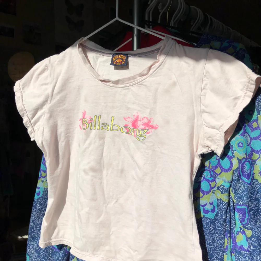 Megagullig och trendig croppad babytee i ljusrosa från märket billabong. 100% bomull. Passar en xs/s typ.. T-shirts.