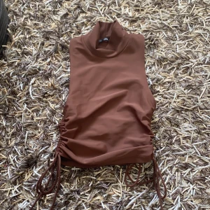 Brun topp med dragsko  - Säljer en brun topp från chiquelle. Använd en gång. Väldigt fin och trendig! Kan mötas upp i Göteborg eller Karlskrona. Annars står köparen för frakten. Vill du även köpa den svarta toppen (exakt lika Dan) kan du du få dem för lite billigare pris!