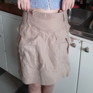 Beige kjol från H&M strl 34 - Snygg kjol med fickor! Har dragkedja på baksidan och hällor för skärp. Går att matcha till det mesta, betalning sker via swish.