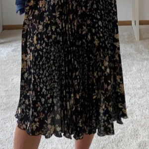 Blommig kjol - Svart blommig kjol i storlek XS men passar XS-M då den är väldigt stretchig. 