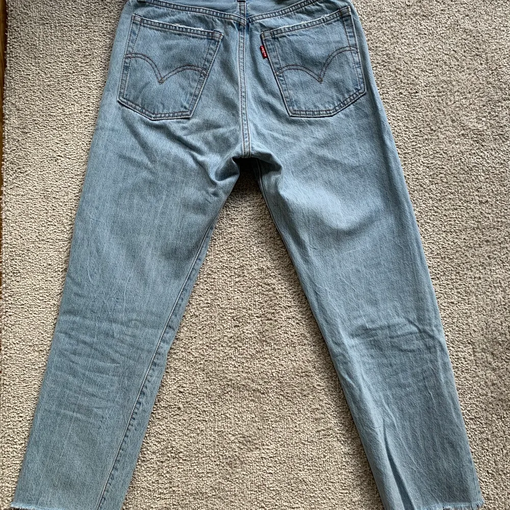 Jeans från Levis med en kortare modell i bena och hög midja, ljus tvätt och ”fransar” nedtill. Fint skick! . Jeans & Byxor.
