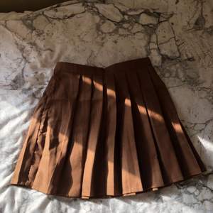 En superfin brun kjol från SHEIN. Liknar en tenniskjol i utseendet men inte i materialet. Helt ny och oanvänd. 🍉🤍