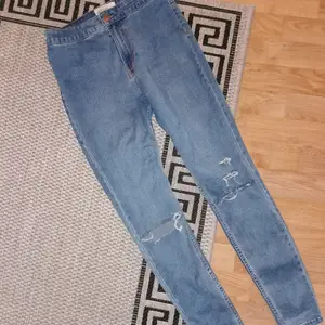 Högmidjade jeans från New look, stl 38. Fabriksgjorda hål över knäna 