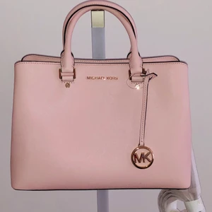 Ny Michael Kors Handväska Rosa Saffiano - Ny oanvänd äkta Michael Kors Handväska i Rosa Saffiano skinn (kostade 4200kr i Michael Kors butik. Obs! Det är enbart handväskan jag säljer. Ta chansen att köpa min rosa Michael Kors handväska för under halva nypriset. Kommer med sina lappar, prislapp och dustbag. 
