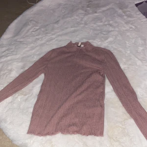 Rosa höghalsad blus - 50 cm lång, 32 cm bred över magen , 55 cm lång arm., jätte skönt material och är från Turkiet 