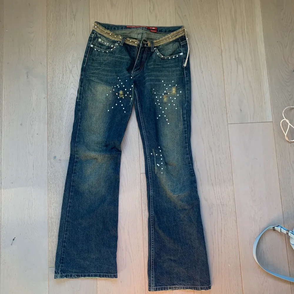 Lågmidjade jeans med Sten detaljer, jag är 175 och jeansen går ner till benen på mig. Färgen är urtvättad blå lite grön med slitningar och snygga detaljer!. Jeans & Byxor.