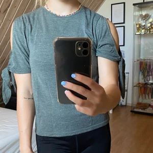 Topp från Zara - Jättefin och skön topp från Zara!!! Cutouts vid axlar/armarna som går att knyta själv. Färgen är grön/grå, nyskick! Hör av er vid frågor eller om ni vill ha fler bilder💞