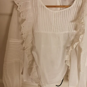 NA-KD - Blus från na-kd med lång ärm och volang. En vit och en ljusblå. Strl 42. Båda i nyskick. 