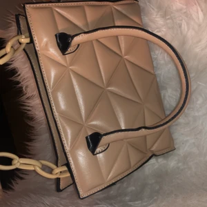 Väska - Man kan ha den som handväska eller axelväska. Du får ett band med som man ser i bilden. Den är beige. Aldrig använt den. Helt ny! 