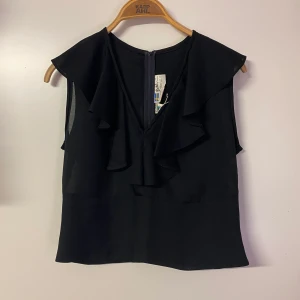 Volangtopp - Söt svart volang topp i storlek 42 men skulle säga att den är liten i storlek och är mer som en storlek M, tror även att om man vanligtvis har storlek S att den kan sitta fint. Frakt tillkommer