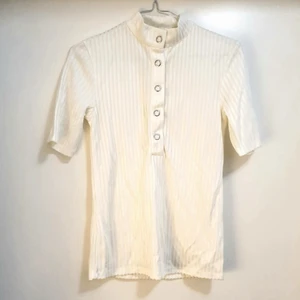 Carin Wester polo - Polo i skimrande vitt material med knappar från Carin Wester för dam i storlek S. Använd 1-2 gånger. 