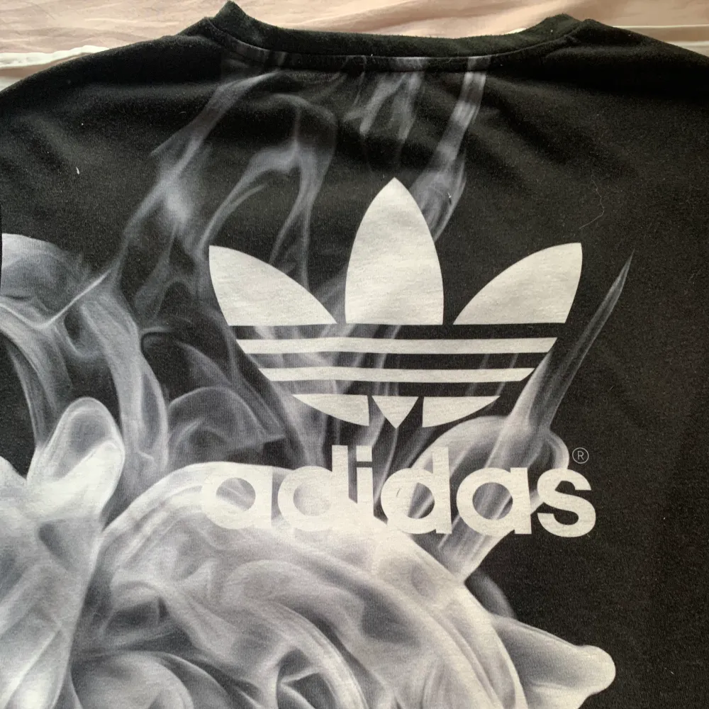 Adidas T-shirt från Rita Ora kollektion. Den är svart med rök mönster både fram och baksida, med även adidas logga på baksida. Mesh på armarna. . T-shirts.