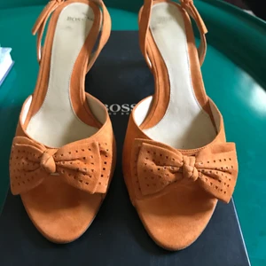 Vintage Hugo Boss klackar - Sparsamt använda klackar från Hugo Boss. Orange färgat läder. Köpta cirka 10 år sedan, säljer åt mammas vännina. Köpta för 2500kr. Inga fläckar eller skador. Som syns på sulan är de knappt använda. Pris kan diskuteras.