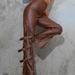 A pair of Brown leather pants with belts on the side. Good quality. Size 10/M. Never worn beacuase they are too big. (regular size 6/8)