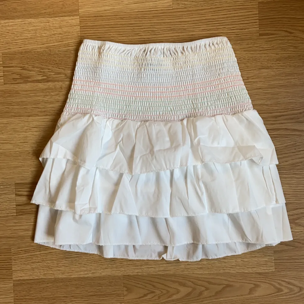 Superfin vit kjol med volanger som passar perfekt till sommaren! Storlek S och aldrig använd! . Kjolar.
