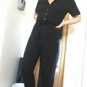 Svart byxdress med knäppning - Byxdress med snörning i midjan och knappar på överdelen, 100% viskos