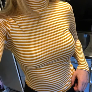 Randig polotröja - Randig gul polotröja från Monki, köpt förra året men aldrig använd då jag inte tycker jag passar i färgen! Står ingen storlek i tröjan men den sitter bra på mig som vanligtvis är 36/38, skulle dock säga att denna är mer som en stl S/36 än M/38. Skriv privat för frågor eller fler bilder! (Köpare står för frakt)