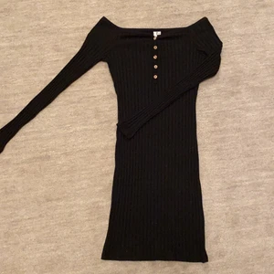  Svart Offshoulder klänning med knapp detaljer - Snygg tight offshoulder klänning med knapp detaljer på framsidan. Använt endast ett fåtal gånger! 