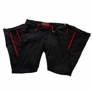 Tripp nyc bondage byxor  - Jättesnygga tripp nyc byxor ❣️ skulle säga att dom är midwaist. Det står storlek 9 men vet inte riktigt vad dom menar men dom passar en M. Dom har skitsnyggt korsettmönster i bak på vaderna och dom är flared out 🌟 Hängslet i bak går att knipsa bort🤍