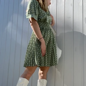 Prickig klänning  - Söt prickig klänning i grönt med vita prickar. Aldrig använd. Klänningen är i storlek M men passar bättre till s-xs 